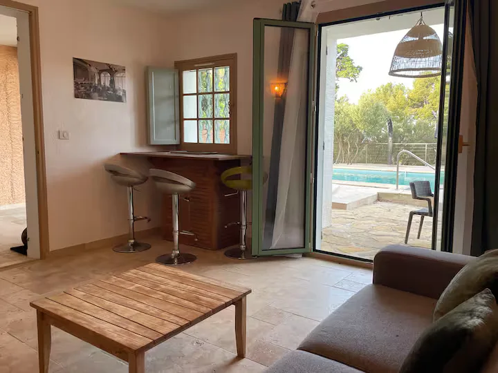 Séjour de la villa donnant sur l'extérieur avec la piscine et disposant d'un bar